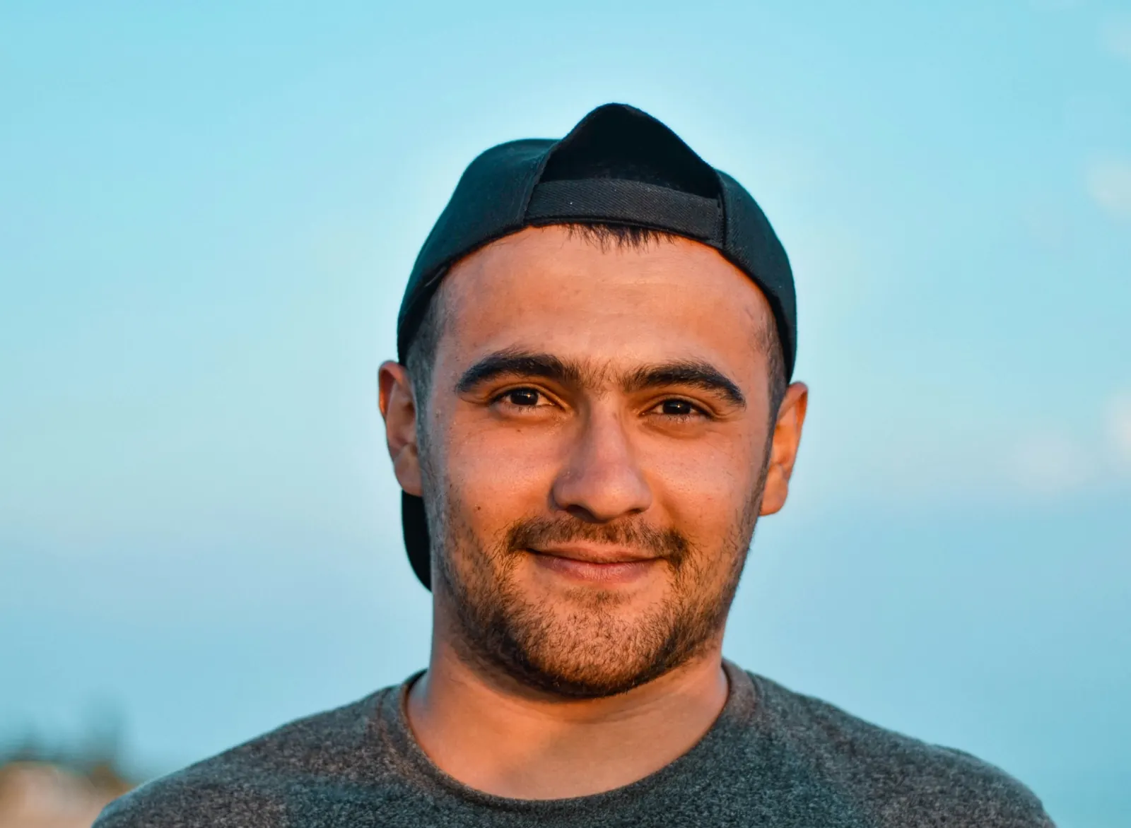 A smiling man in a cap, photographed outdoors