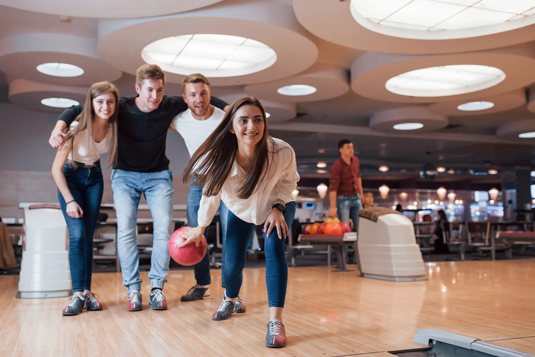 Friends cheering each other on at the bowling alley