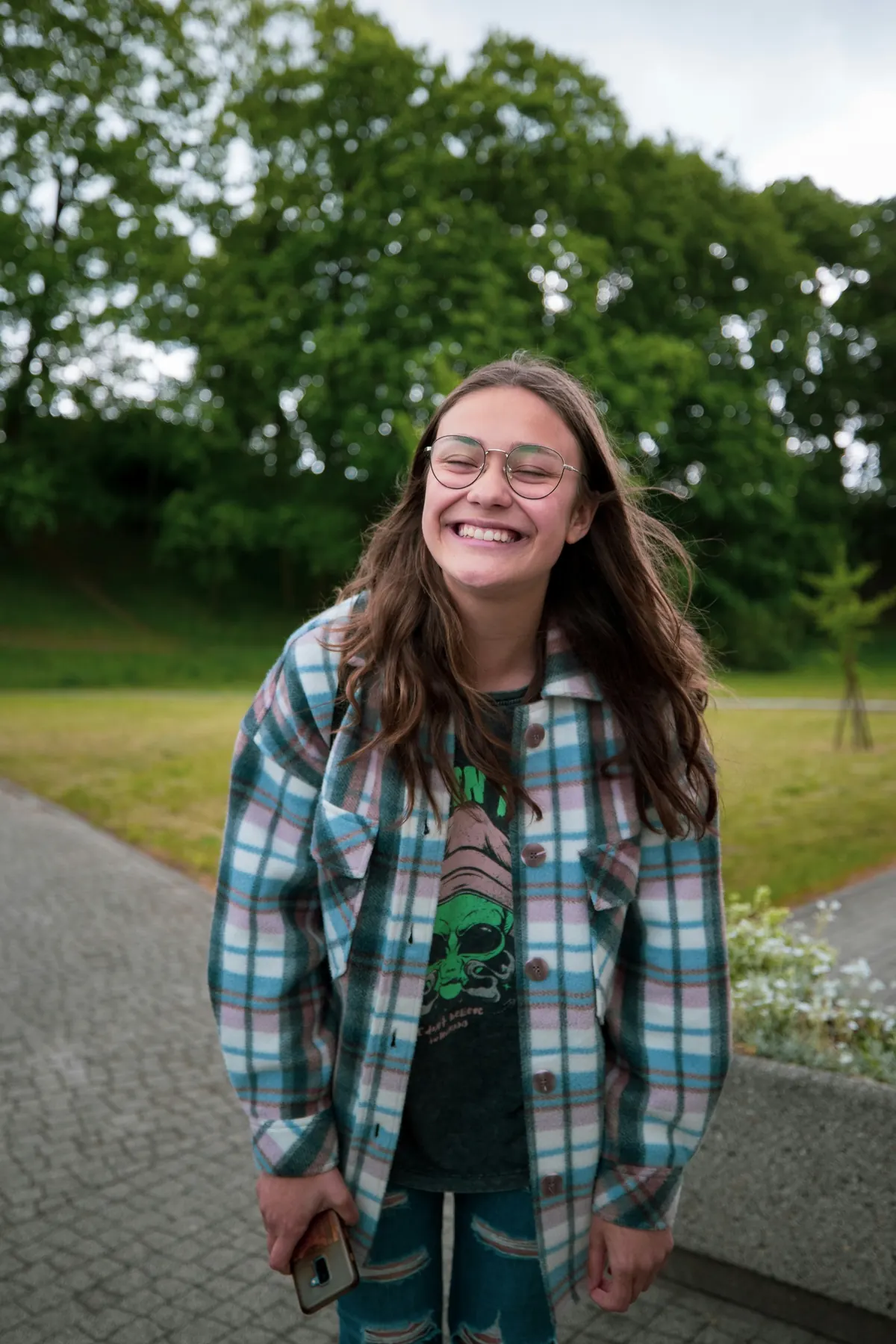 A teenage girl laughing outdoors
